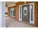 Inviting front porch with detailed glass front door, white trim and pillars, with a view of the lawn at 5635 Upper Creek Ct, Suwanee, GA 30024