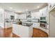 Bright kitchen features white cabinets, a large island with dark countertops, and stainless steel appliances at 5635 Upper Creek Ct, Suwanee, GA 30024