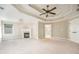 Spacious main bedroom with a fireplace, tray ceiling, and doorway leading to the ensuite bathroom at 5635 Upper Creek Ct, Suwanee, GA 30024