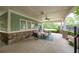 Covered outdoor patio with comfortable seating and a view of the community tennis courts at 5635 Upper Creek Ct, Suwanee, GA 30024