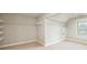 This expansive walk-in closet offers ample storage space with shelving and a window for natural light at 5635 Upper Creek Ct, Suwanee, GA 30024