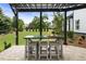 Inviting patio with a pergola covering a dining table with seating and a manicured backyard at 4010 Cameron Ct, Cumming, GA 30040