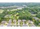 A high-angle aerial shot displays the neighborhood, emphasizing the home's placement amidst ample greenery and amenities at 470 Wagon Hill Ln, Sugar Hill, GA 30518