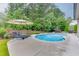 Charming backyard featuring a sparkling pool, lounge chairs, landscaped surroundings, and an umbrella at 470 Wagon Hill Ln, Sugar Hill, GA 30518