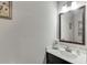 Powder room with white countertop, dark cabinets, framed mirror, and decorative towel at 470 Wagon Hill Ln, Sugar Hill, GA 30518