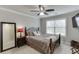 Cozy bedroom with a dark wooden bed frame, a ceiling fan, and a bright window at 470 Wagon Hill Ln, Sugar Hill, GA 30518