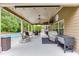 Inviting covered patio with ceiling fans, outdoor dining, rocking chairs, and a serene view of the pool at 470 Wagon Hill Ln, Sugar Hill, GA 30518