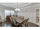 Traditional dining room showcases elegant wainscoting, tray ceilings, and stylish chandelier at 470 Wagon Hill Ln, Sugar Hill, GA 30518