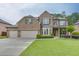 Beautiful brick two-story home featuring a three car garage and lush, well-manicured front lawn at 470 Wagon Hill Ln, Sugar Hill, GA 30518