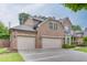 Side view of brick two-story home showcasing its three-car garage and beautifully landscaped yard at 470 Wagon Hill Ln, Sugar Hill, GA 30518