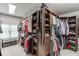 Corner walk-in closet with custom storage, shelving, drawers, carpeted floors, window bench and natural light at 470 Wagon Hill Ln, Sugar Hill, GA 30518