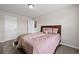 Bedroom featuring neutral carpet, a bed with pink bedding, two doorways, and a window with a neighborhood view at 397 Victory Ln Ln, Locust Grove, GA 30248