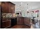 This open kitchen features dark cabinetry, black appliances, hardwood floors, and a view to the breakfast nook at 397 Victory Ln Ln, Locust Grove, GA 30248