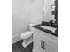Modern half-bath features a black granite countertop and black hardware at 4927 Slaton Dr, Acworth, GA 30101