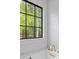 Bright bathroom featuring a black-trimmed window with scenic nature views and white herringbone tile backsplash at 4927 Slaton Dr, Acworth, GA 30101
