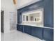 Spacious bathroom with custom blue cabinetry, marble floors, backlit mirror, and a glass shower with gold hardware at 4927 Slaton Dr, Acworth, GA 30101