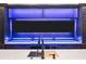 Dark cabinets with three TVs underlit with blue lights, white countertop, and a stainless steel sink at 4927 Slaton Dr, Acworth, GA 30101