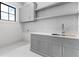 Chic laundry room with stylish gray cabinets, a floating shelf, and a subway tile backsplash at 4927 Slaton Dr, Acworth, GA 30101