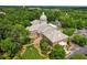 Aerial view of a grand building surrounded by lush green trees at 620 Neel Reid Dr, Roswell, GA 30075