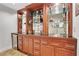 Custom home bar featuring wooden cabinetry, a beverage fridge, and glass shelving at 620 Neel Reid Dr, Roswell, GA 30075