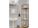 Bathroom featuring a pedestal sink, large mirror, and decorative shelving at 620 Neel Reid Dr, Roswell, GA 30075