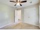Carpeted bedroom with ceiling fan, double door closet and view of an adjoining room at 130 Stewart Hollow Ln, Covington, GA 30016
