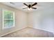 Neutral bedroom featuring a ceiling fan, carpeted floor, and a window with natural light at 130 Stewart Hollow Ln, Covington, GA 30016