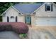 Close up of a brick home with a two car garage, lush landscaping and a pop of color from the front door at 130 Stewart Hollow Ln, Covington, GA 30016