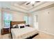 Bright, spacious main bedroom featuring a tray ceiling, ceiling fan, and carpet floors at 130 Stewart Hollow Ln, Covington, GA 30016