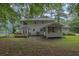 Back exterior featuring a deck and screened in porch in a tree filled yard at 2055 Pinella Dr, Grayson, GA 30017
