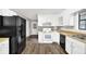Well-lit kitchen features wood floors, white cabinets, and black appliances at 2055 Pinella Dr, Grayson, GA 30017