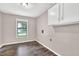 Laundry room features wood flooring, cabinet space, and a window at 2055 Pinella Dr, Grayson, GA 30017