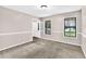 Neutral carpeted living room with natural light from dual windows and doorway at 2055 Pinella Dr, Grayson, GA 30017