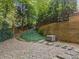 Picturesque backyard featuring a stone retaining wall, generator, and rock pathway at 4304 Berkford Ne Cir, Brookhaven, GA 30319