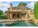 Beautiful backyard pool area with stone accents, covered patio, and well-maintained landscaping at 4304 Berkford Ne Cir, Brookhaven, GA 30319