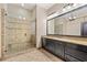 Bathroom with a glass shower, granite counters, and a large framed mirror with vanity lighting at 4304 Berkford Ne Cir, Brookhaven, GA 30319
