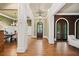 Elegant foyer with hardwood floors, white columns, and arched doorways to adjacent rooms at 4304 Berkford Ne Cir, Brookhaven, GA 30319