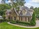 Well-maintained brick home with lush landscaping, mature trees, and a circular driveway at 4304 Berkford Ne Cir, Brookhaven, GA 30319