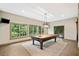 Basement game room with pool table, chandelier and large windows, perfect for entertaining guests at 4304 Berkford Ne Cir, Brookhaven, GA 30319