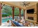Inviting outdoor patio featuring a brick fireplace, ceiling fan, stone flooring, and a view of the swimming pool at 4304 Berkford Ne Cir, Brookhaven, GA 30319