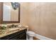 Elegant powder room featuring a granite countertop, decorative mirror, and stylish fixtures at 4304 Berkford Ne Cir, Brookhaven, GA 30319