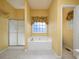Bathroom with a soaking tub under a window and a glass-enclosed shower at 5 Glenn Eagles Vw, Hiram, GA 30141