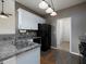 Galley kitchen with white cabinets, stainless steel appliances and access to dining area at 5 Glenn Eagles Vw, Hiram, GA 30141