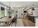 Well-lit dining area with wood table, modern chandelier, hardwood floors, and view to kitchen at 5330 Keepsake Court, Cumming, GA 30040