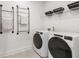 Modern laundry room with front-load washer/dryer units and industrial towel racks at 5330 Keepsake Court, Cumming, GA 30040