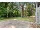 Home has a basketball hoop, lush lawn with trees and a bench in the back yard at 6192 Holiday Blvd, Forest Park, GA 30297