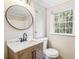 Updated bathroom featuring a modern vanity, round mirror, and new fixtures at 6192 Holiday Blvd, Forest Park, GA 30297
