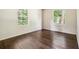Sunlit bedroom with hardwood floors and two windows providing natural light at 6192 Holiday Blvd, Forest Park, GA 30297