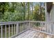 This deck has wood floors with a rail, and is surrounded by a lush green forest at 6192 Holiday Blvd, Forest Park, GA 30297