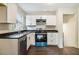 Modern kitchen featuring sleek black countertops, white cabinetry, and new stainless steel appliances at 6192 Holiday Blvd, Forest Park, GA 30297